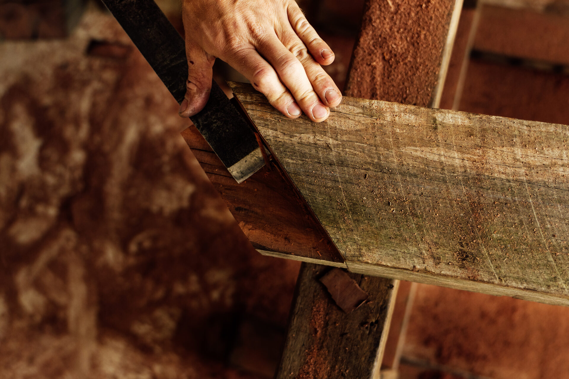 Close view of hands aligning the halved corner joint of two hardwood beams.